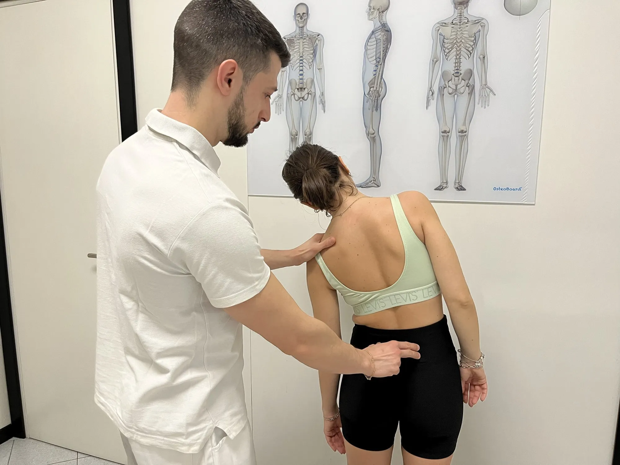 Valutazione posturale in piedi durante una seduta di osteopatia