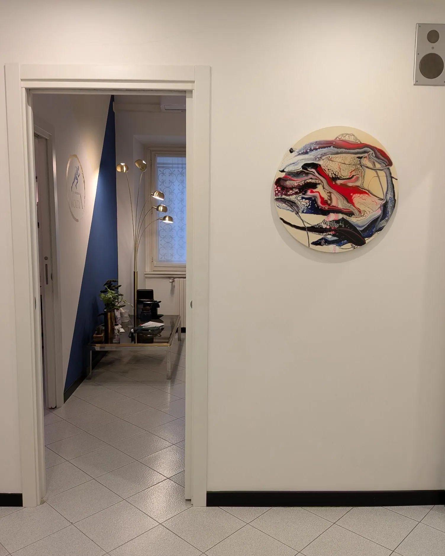 Il corridoio d’ingresso di Studio Volta, con la sala d’attesa e il logo sullo sfondo
